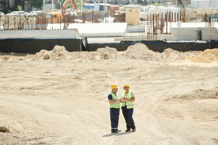 Two construction workers examining a site